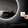 A hand is shown pressing a light switch next to a large, illuminated round mirror in a modern bathroom setting. Produktbild-Vorschau