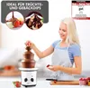 A woman is using a chocolate fountain to dip strawberries. Podgląd zdjęcia produktu