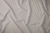 A close-up view of a beige and gray striped bedsheet. Anteprima dell’immagine prodotto