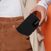 A person is placing a black phone case with a transparent window into their corduroy pants pocket. Náhled obrázku produktu