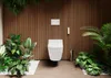 A modern toilet with a wooden slatted wall background, surrounded by lush greenery and white pebbles. Podgląd zdjęcia produktu