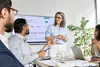 A group of people in a meeting room, with a woman presenting in front of a large screen. Voir les images du produit