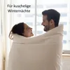 A couple is wrapped in a blanket, looking at each other. Produktbild-Vorschau