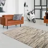 A modern living room with a brown leather sofa, a patterned rug, and a white scooter. Voir les images du produit