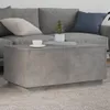 A modern living room scene with a grey sectional sofa and a concrete-look coffee table. Produktbild-Vorschau