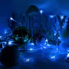 Christmas decorations with blue lights, ornaments, and a "Merry Christmas" sign. Produktbild-Vorschau