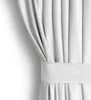 A close-up view of a white curtain with pleats and a fabric band. Produktbild-Vorschau