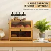 A kitchen counter with a bamboo bread box, jars, a plant, and a teacup. Produktbild-Vorschau