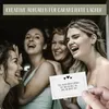 Four women laughing together, with one holding a card. Produktbild-Vorschau