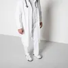 A person wearing a white lab coat and white pants, with a stethoscope around their neck, stands in front of a white wall. Náhľad obrázku produktu