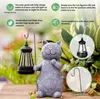 A solar-powered cat figurine with a lantern in a garden setting, surrounded by plants. Produktbild-Vorschau