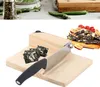 A close-up of a wooden guillotine-style slicer with a knife and some cut food items. Náhled obrázku produktu