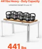 A white AC stand is shown with several 50lb kettlebells on top to demonstrate its heavy-duty capacity. Podgląd zdjęcia produktu