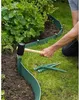 A person is installing garden edging around a plant bed using a mallet and stakes. Produktbild-Vorschau