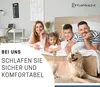 A family and their dog are lying on a bed in a bedroom. Produktbild-Vorschau