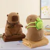 Two plush capybara toys are displayed on a bed or table, each with a blanket. Podgląd zdjęcia produktu