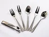 A collection of silverware, including forks, spoons, and tongs, arranged on a white background. Produktbild-Vorschau