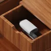 A white and gray handheld garment steamer is placed inside a wooden drawer. Produktbild-Vorschau