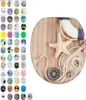 A collage of toilet seat designs, with one design prominently displayed in the center featuring a maritime theme with a life preserver, starfish, rope, and compass on a wooden background. Náhled obrázku produktu