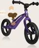 A purple balance bike for children is shown against a light beige background. Produktbild-Vorschau