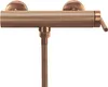 A copper-colored shower faucet with a ribbed texture and a flexible hose attached. Produktbild-Vorschau