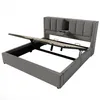 A grey upholstered bed frame with the mattress support mechanism lifted to reveal storage space underneath. Produktbild-Vorschau