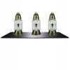 Three glass grave lanterns with gold-colored metal accents are arranged on a black shelf against a white background. Náhled obrázku produktu