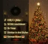 A split image showing a Christmas fireplace scene on the left and a decorated Christmas tree on the right, with product features listed on the left. Produktbild-Vorschau