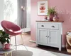 A modern living room corner with a pink chair, a white and wood sideboard, and decorative items. Voir les images du produit