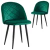 Two dark green velvet dining chairs with black metal legs are shown against a white background. The chair in the foreground is angled slightly towards the viewer, while the chair in the background is positioned further back and to the right. Podgląd zdjęcia produktu