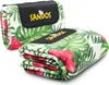 Two folded picnic blankets with a tropical leaf and flower pattern, one in front of the other. Náhled obrázku produktu
