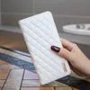 A hand holding a white quilted phone case. Produktbild-Vorschau