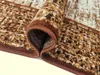 A close-up view of a rolled-up rug, showing the texture and edge binding. Náhled obrázku produktu
