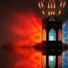 A decorative lantern casting colorful light patterns on a reflective surface and wall. Podgląd zdjęcia produktu