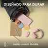 A collection of pink tech accessories, including a keyboard, mouse, and headphones, are spilling out of a black bag, along with a phone and notebooks, on a light yellow background. Produktbild-Vorschau