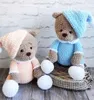 Two crocheted teddy bears dressed in pajamas and sleeping caps, sitting on a basket. Anteprima dell’immagine prodotto