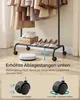 A SONGMICS clothing rack with clothes hanging on top and shoes on the bottom shelf. A robotic vacuum cleaner is shown underneath the rack to demonstrate clearance. The bottom of the image shows close-ups of the wheels. Produktbild-Vorschau