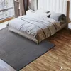 A bedroom scene with a bed and a rug. Produktbild-Vorschau