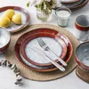 A table setting with plates, bowls, cutlery, lemons, and a candle. Náhled obrázku produktu
