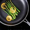 Asparagus and lemon slices are being cooked in a non-stick pan on a stovetop. Náhled obrázku produktu