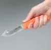 A hand holding an orange-handled knife with a curved blade. Náhled obrázku produktu