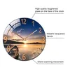 A round wall clock with a sunset landscape image and text describing its features. Voir les images du produit