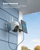 A solar-powered security camera mounted on the side of a house, connected to a solar panel. Produktbild-Vorschau