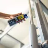 A hand holding a can of RUNIX Laufband-Schmiermittel, spraying it onto a treadmill rail. Podgląd zdjęcia produktu
