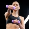 A woman is exercising with dumbbells in a gym. Náhled obrázku produktu