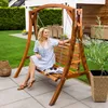 A woman sits on a wooden garden swing in a backyard setting. Náhled obrázku produktu