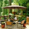 A patio umbrella and chairs on a wooden deck surrounded by trees. Produktbild-Vorschau