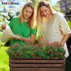 Two women are gardening, one watering plants in a wooden planter box. Anteprima dell’immagine prodotto