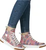 A pair of high-top sneakers with a floral pattern worn by a person. Voir les images du produit