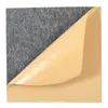 A close-up view of a dark gray acoustic panel with a tan protective backing peeling away. Podgląd zdjęcia produktu